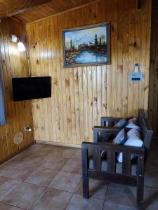 Habitación con TV y sofá. en Cabañas Nativa en Montecarlo