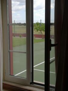 新蒙特莫爾的住宿－JOHN's Farm Country HOUSE，从窗户可欣赏到网球场的景色