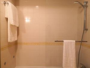 a bathroom with a tub and a shower with towels at JOHN's Farm Country HOUSE in Montemor-o-Novo