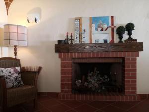 a living room with a brick fireplace and a chair at JOHN's Farm Country HOUSE in Montemor-o-Novo