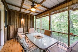 una veranda riparata con tavolo e sedie di Lake Cumberland Resort Cabin with Community Perks! a Burnside