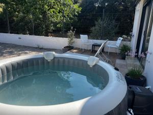 a hot tub in a backyard with a table and chairs at Maisonnette 32m2 climatisé avec jacuzzi au calme. in Trans-en-Provence