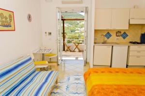 una cocina y un dormitorio con 2 camas y una mesa en Sunset Village Ponza, en Ponza