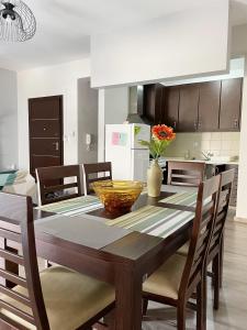 uma cozinha com uma mesa com cadeiras e uma sala de jantar em Nikolas Apartment em Alexandroupoli