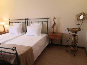Dormitorio con cama con espejo y estatua de jirafa en JOHN's Farm Country HOUSE, en Montemor-o-Novo 52 fotos más