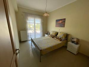 um quarto com uma cama grande e uma janela em Cozy apartment Kokkoni beach em Kokkónion