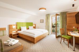 a hotel room with a bed and a table and a desk at Landhotel Stofflerwirt in Sankt Michael im Lungau +79 photos