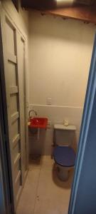 uma pequena casa de banho com um WC e um lavatório vermelho em Casa de Avó!! Agradável e aconchegante em Uberaba