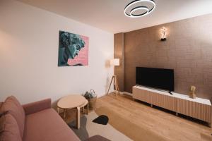 sala de estar con sofá y TV de pantalla plana en Cotroceni Accommodations, en Bucarest