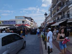 a group of people walking down a busy city street at MYRTOS ROOMS in Paralia Katerinis