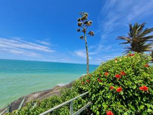 a view of the ocean and a palm tree at GUARALOFT ARUBA NO MIRANTE DE GUARAPARI in Guarapari