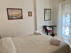 una camera con un letto bianco e una sedia di Casabella a Tortoreto