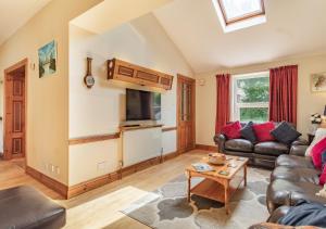a living room with a couch and a tv at Fieldview in East Barsham