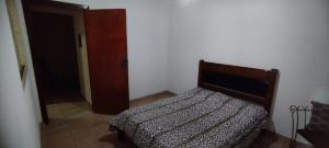 a bedroom with a bed in the corner of a room at Casa de Boneca aconchegante in Uberaba