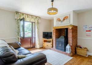 sala de estar con sofá y chimenea en Oak Cottage en Dulverton