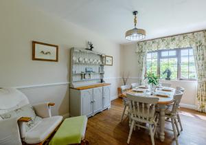 cocina y comedor con mesa y sillas en Oak Cottage en Dulverton