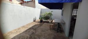 un patio con una mesa y una sombrilla azul en Casa Lá Vita en Uberaba