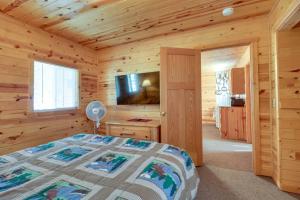 ein Schlafzimmer mit einem Bett in einem Blockhaus in der Unterkunft Walleye Cabin on Mille Lacs Lake Boat and Fish! in Garrison