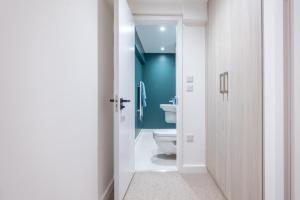 a bathroom with a toilet and a blue wall at Stunning 2BD Apartment in Manchester in Manchester