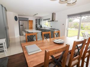 a kitchen and dining room with a wooden table and chairs at 17 Clover Hill in Killorglin