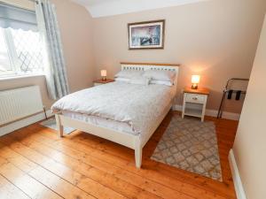 een slaapkamer met een wit bed en 2 lampen bij 17 Clover Hill in Killorglin