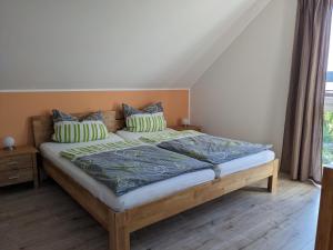 um quarto com uma cama de madeira com lençóis e almofadas verdes em Ferienwohnung Pappelwende em Ostseebad Karlshagen