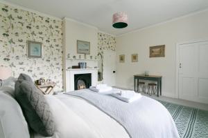 a bedroom with a white bed and a fireplace at Stay On The Hill - The Coach House in Hexham