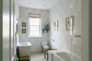 y baño con lavabo, bañera y aseo. en Stay On The Hill - The Coach House en Hexham