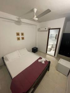Un dormitorio con una cama con una toalla. en Habitaciones en el Rodadero Sur en Gaira