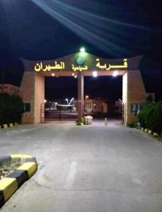 Una gasolinera por la noche con un cartel. en شالية عائلي بالساحل الشمالي, en Dawwār Abū Maḩrūs