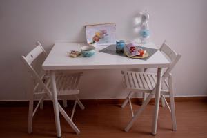 a white table with two chairs and a plate of food at Villa Susanna in Civitavecchia