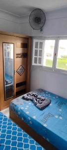 1 dormitorio con 1 cama en una habitación con ventanas en شالية عائلي بالساحل الشمالي, en Dawwār Abū Maḩrūs