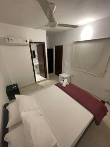 Un dormitorio con una gran cama blanca con un osito de peluche. en Habitaciones en el Rodadero Sur en Gaira