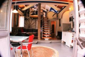 a living room with a table and a spiral staircase at zentralclub apartamento vatio- jacuzzi in Belmonte de Miranda