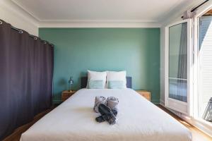 Un dormitorio con una cama grande con zapatos. en Modern&Confort Fully Furnish Apartment ⭑ La Défense ⭑Champs Elysées⭑ RER A & L, en Maisons-Laffitte