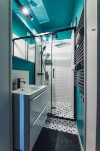 y baño con ducha acristalada y lavamanos. en Modern&Confort Fully Furnish Apartment ⭑ La Défense ⭑Champs Elysées⭑ RER A & L, en Maisons-Laffitte