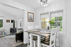 a white dining room with a table and chairs at 79 West Road Orleans Cape Cod - Bed Splash & Beyond in Orleans