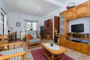 a living room filled with furniture and a flat screen tv at Villa Eucalipto in Lagoa
