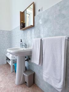 a bathroom with a sink and a mirror and towels at B&B Villa Susanna in Civitavecchia