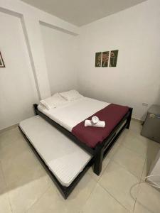 1 dormitorio con 2 camas y toallas. en Habitaciones en el Rodadero Sur en Gaira