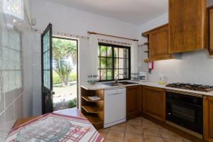 a kitchen with a sink and a stove at Villa with Private Pool Near Benagil & Marinha Beach in Lagoa
