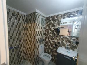een badkamer met een toilet, een wastafel en een spiegel bij Dimora Gold Hotel in Trabzon