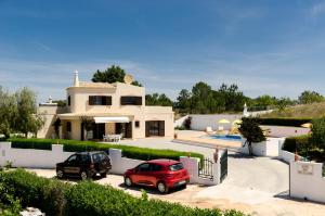 una casa con dos coches estacionados frente a ella en Villa Eucalipto en Lagoa