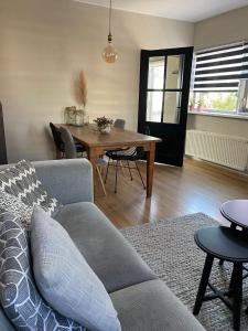 een woonkamer met een bank en een tafel bij Guesthouse Katwijk aan Zee in Katwijk aan Zee