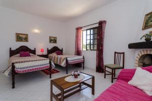 a living room with two beds and a table at Villa with Private Pool Near Benagil & Marinha Beach in Lagoa +23 photos