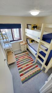 a dorm room with two bunk beds and a rug at Bosun`s Cottage Luxury stay in the heart of town in Weymouth