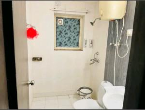 een badkamer met een toilet en een raam bij Ac Beautiful Luxury stay in Omaxe Vrindavan Jai bankebihariji by Shishamare in Vrindāvan
