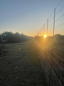 a fence with the sun setting behind it at Kings view exclusive villas (KVEV) in Pretoria-Noord