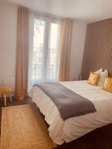 een slaapkamer met een groot bed en een raam bij Comme à la maison-Porte de Paris in Pantin