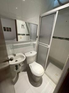 y baño con aseo, lavabo y ducha. en Habitaciones en el Rodadero Sur en Gaira